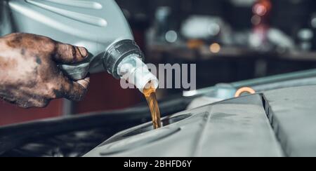 verser de l'huile neuve dans le moteur de la voiture à partir du réservoir pendant le remplacement Banque D'Images