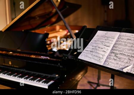 Perm, Russie - 18 mars 2020: Score pour le violoniste et le piano à queue flou dans une salle de concert sombre Banque D'Images