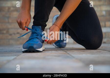 Femme qui a noué ses chaussures avant de faire la salle de gym.fille déterminisée à la salle de gym prête à commencer la leçon de fitness.force et motivation Banque D'Images