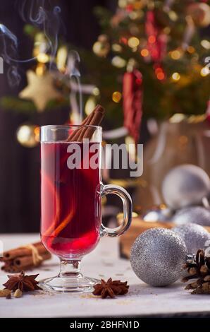 Verre tasse de vin chaud sur fond de décorations de noël Banque D'Images