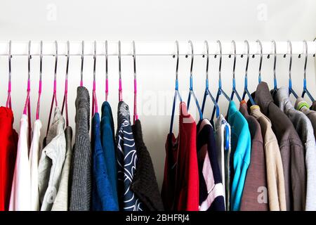 Vêtements pour hommes et pour femmes sur cintres en silicone dans le placard de la penderie. Les mêmes épaules. Organisation du stockage. Ordre et propreté. Quarantaine, se Banque D'Images