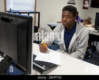 Houston, Texas juin 2012 : un étudiant afro-américain prend des notes dans un laboratoire d'informatique à une école secondaire de charte publique. ©Marjorie Kamys Cotera/Daemmrich Photographie Banque D'Images