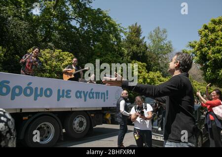 Athènes, Grèce. 25 avril 2020. La chanteuse grecque Alkistis Protopsalti (1ère L) interagite avec le Premier ministre grec Kyriakos Mitsotakis (R, Front) lors d'un concert de "voyage" sur un camion à Athènes, Grèce, le 25 avril 2020. Le concert "itinérant" a été organisé par la ville d'Athènes avec un camion faisant de courtes arrêts sur les places et les hôpitaux pour exprimer sa gratitude à ceux qui combattent la COVID-19 sur la ligne de front et diffuser un message d'espoir et de solidarité avec le peuple d'Athènes. Crédit: Lefteris Partsalis/Xinhua/Alay Live News Banque D'Images