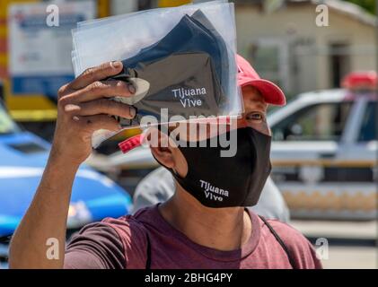 Tijuana, Basse-Californie, Mexique. 25 avril 2020. Un homme de Tijuana, au Mexique, vend des masques près du poste frontalier de San Ysidro US/Mexique. Tijuana connaît un très grand nombre de cas de coronavirus qui sont en train de mettre en valeur la capacité de soins des patients des hôpitaux locaux‚ à„. Crédit: David Barak/ZUMA Wire/Alay Live News Banque D'Images