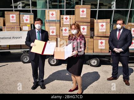 (200426) -- TIRANA, le 26 avril 2020 (Xinhua) -- l'ambassadeur chinois en Albanie Zhou Ding (L) échange des certificats de remise avec le sous-ministre albanais de la Santé et de la protection sociale Mira Rakacolli (C) lors d'une cérémonie à l'aéroport international de Tirana, Albanie, le 25 avril 2020. Un lot de fournitures médicales données par le gouvernement chinois est arrivé samedi à l'aéroport international de Tirana en Albanie pour aider le pays à lutter contre la pandémie de coronavirus. Les fournitures médicales comprennent des kits de test, des vêtements de protection, des masques pour le visage, des lunettes et des gants. (Ambassade de Chine en Albanie/document d'informations via Xinh Banque D'Images