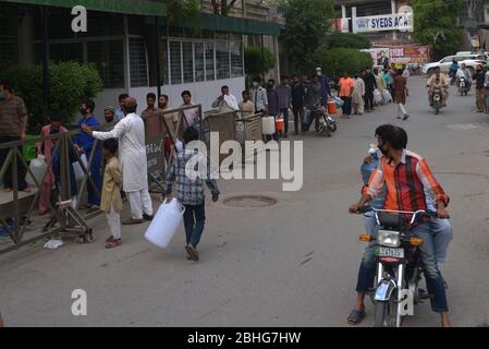 Lahore, Pakistan. 25 avril 2020. Un grand nombre de Pakistanais sont en file d'attente à l'usine de filtration de l'eau sans distancer les populations au cours du premier jour du mois sacré musulman du Ramadan-ul-Moubarak à Lahore. Des millions de musulmans ont commencé le Ramadan, le mois le plus sacré du calendrier islamique, sous le verrouillage du coronavirus ou des restrictions sociales strictes du gouvernement pakistanais. (Photo de Rana Sajid Hussain/Pacific Press) crédit: Pacific Press Agency/Alay Live News Banque D'Images