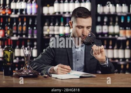 Sommeliers homme dégustation de vin rouge et notes arôme degustation carte Banque D'Images