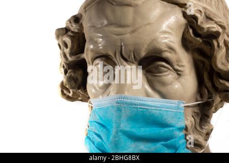 Copie en gypse de l'ancien Homer statue portant un masque de visage de virus Banque D'Images