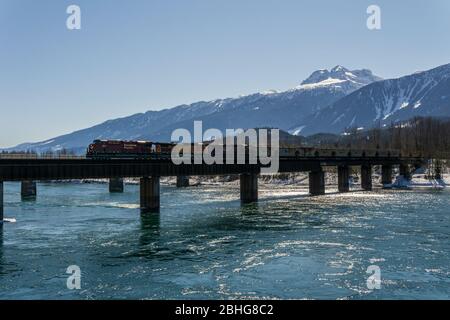 REVELSTOKE, CANADA - le 15 MARS 2020 : pont ferroviaire du train de marchandises traversant la rivière columbia le printemps. Banque D'Images