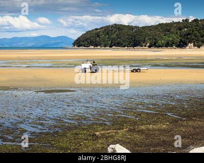 Tracteur d'algues et de kayaks à marée basse, Sandy Bay, Marahau, Tasman, Nouvelle-Zélande Banque D'Images