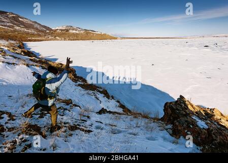 Lac Baikal, Russie - 8 mars 2020: La vue de l'homme de l'arrière montre la figure et le fond s'avère être des silhouettes obscueuses. Lac gelé Baikal Banque D'Images