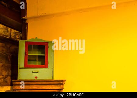 L'armoire médicale du bois et du plâtre peint jaune. Banque D'Images