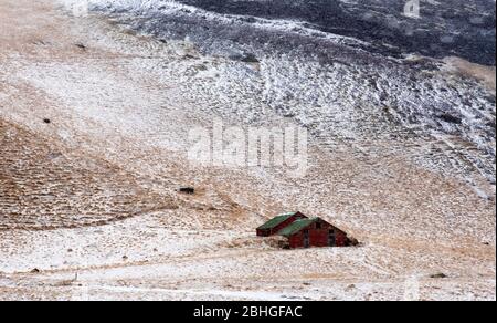 Paysage islandais typique de la péninsule de Reykjavik avec des montagnes couvertes de neige et des maisons de stockage solitaire dans le champ Banque D'Images