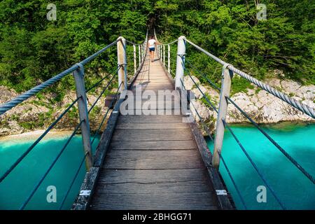 Superbe sentier de randonnée avec randonneur sur le pont suspendu au-dessus de la rivière Isonzo dans la forêt, Kobarid, Slovénie, Europe Banque D'Images