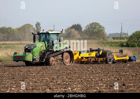 Tracteur à chenilles Fendt remorquant l'équipement de travail du sol TWB ; haviron de champs secs poussiéreux en avril, Lancashire, Royaume-Uni Banque D'Images