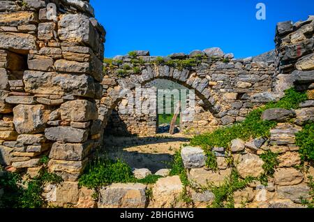 Ruines de la porte en forme d'arche et les murs restants d'un ancien monastère situé au sommet d'une petite colline près de Neapoli en Crète. Banque D'Images