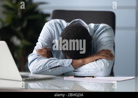 Homme d'affaires africain fatigué qui dormait au bureau. Banque D'Images