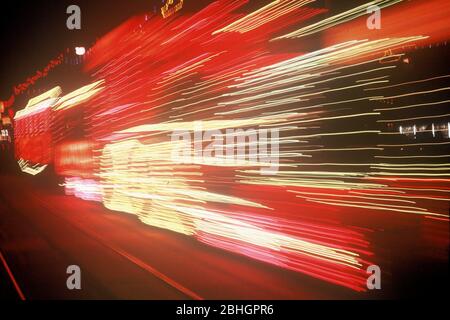 Un tramway illuminé flou pendant les illuminations de Blackpool dans le Lancashire, en Angleterre, au Royaume-Uni, se déplaçant le long de la promenade. Photo prise dans les années 1970. Banque D'Images