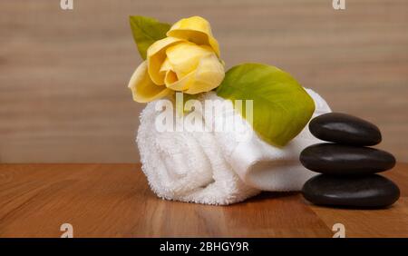 Rouleau de serviettes blanches sur la table, fleur jaune - avec espace de copie. Photo de fond du spa - baners. Banque D'Images