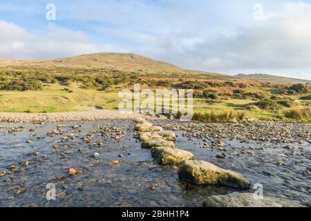 Des pierres sur la rivière Lyd mènent vers Brat Tor et la Croix de la Widgery, le parc national de Dartmoor, Devon, Angleterre, Royaume-Uni. Banque D'Images