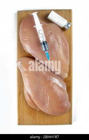 Seringue avec un liquide est injecté à un morceau de viande. Illustration conceptuelle pour les Hormones et d'antibiotiques dans la production alimentaire. Concept d'OGM. Isolé Banque D'Images