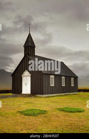 La petite église en bois noir près de Budir dans le nord de l'Islande. Banque D'Images