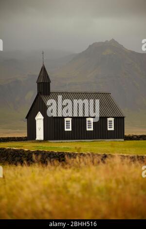 La petite église en bois noir près de Budir dans le nord de l'Islande. Banque D'Images