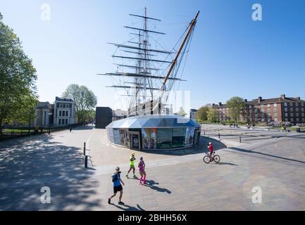 Trois coureurs prennent un selfie lorsqu'ils passent le Cutty Sark, à Greenwich, au cours du marathon de Londres, qui a été reporté pour aider à freiner la propagation du coronavirus. Banque D'Images