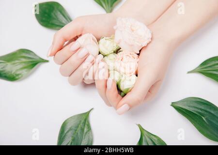 Belle manucure féminine rose tendance avec fleur sur fond, vue sur le dessus. Concept bio nature cosmétiques soins de la peau Banque D'Images