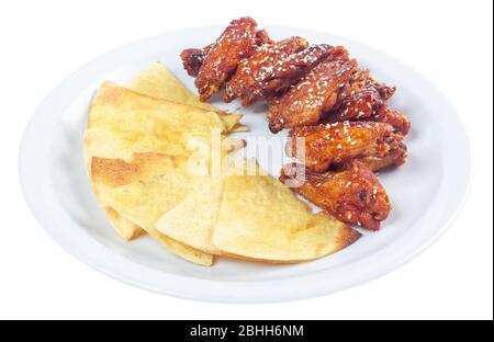 ailes de poulet dans la sauce épicée. plat de pub populaire. beau concept de nourriture de pourries. isolé sur une plaque blanche. Banque D'Images