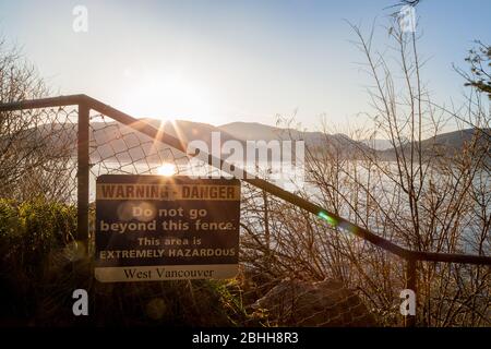 WEST VANCOUVER, C.-B., CANADA - 18 MARS 2020 : un panneau d'avertissement pour la falaise au parc Whytecliff au coucher du soleil. Banque D'Images