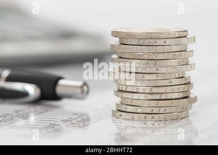 Pièces empilées de monnaie européenne calculatrice à proximité Banque D'Images
