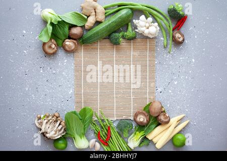 ingrédients frais de cuisine asiatique : pak choy, maïs pour bébé, champignons et épices sur fond gris. vue de dessus. espace de copie Banque D'Images