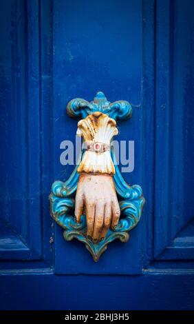 Défonce de porte en forme de main sur une porte bleue Banque D'Images