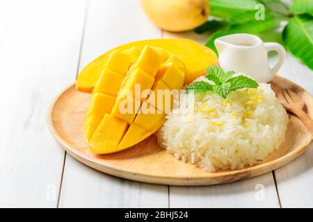 Mangue mûre et riz collant avec lait de coco sur fond de bois blanc, dessert thaïlandais en été Banque D'Images