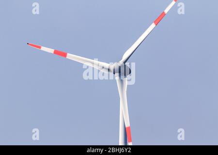 Portrait de clôture d'une éolienne blanche dans un ciel bleu avec des marques rouges sur celle-ci. L'énergie éolienne et d'autres sources d'énergie écologique seront l'avenir. Banque D'Images