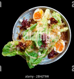 Salade César cuite de façon asiatique, isolée sur fond noir, chemin de découpe Banque D'Images