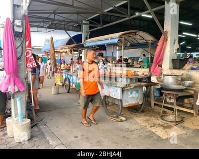 Photo d'un homme locale thaïlandaise en orange t-shirt est en marche avant de la street market dans Paknampran Hua Hin, Thaïlande 22 décembre 2018 Banque D'Images