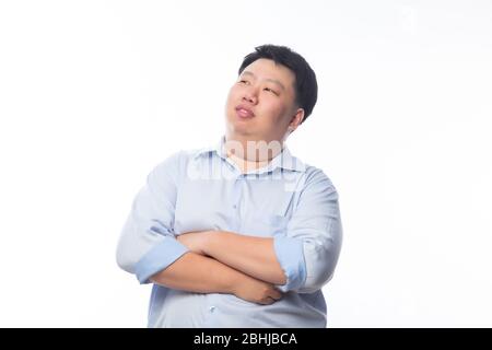 Asian Fat Man dans le bras de chemise bleu croisé et regardant à l'recopie avec le visage heureux isolé sur fond blanc. Banque D'Images