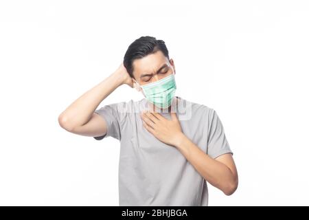 Jeune homme asiatique dans un masque hygiénique souffrant de mal de gorge et ayant la grippe, 2019-nCoV ou coronavirus. Maladie respiratoire aérienne comme les combats de pm 2.5. Banque D'Images