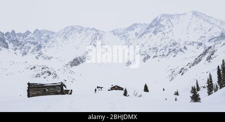 Ancienne cabine avec montagnes en arrière-plan dans un cadre d'hiver Banque D'Images