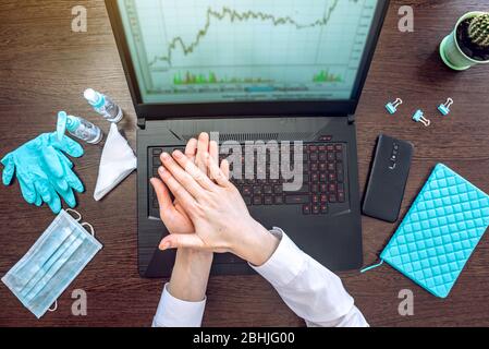 Une femme qui applique un désinfectant à ses mains avant de travailler à l'ordinateur au bureau. Propreté et hygiène dans la lutte contre les virus Banque D'Images