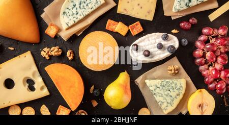 Panorama plat de fromage. De nombreux fromages différents, tirés d'en haut sur un fond sombre Banque D'Images