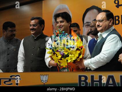 L'ancien chef du Congrès, Jyotiraditya Scindia, centre, reçoit un bouquet du président du Parti Bharatiya Janata, J.P Nadda, lors d'une presse Banque D'Images