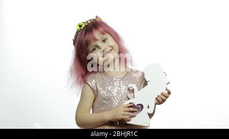 Une princesse de petite fille souriante tient un cadre photo en bois sous forme de femme enceinte avec photo à ultrasons. Fond blanc. Un enfant mignon qui aime l'enfance. Concept de la fête des mères Banque D'Images