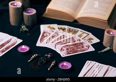 Bougies et vieilles cartes tarot sur soie sombre. Halloween et concept de récit de fortune. Fond mystique avec objets occultes et magiques sur table de sorcière. Banque D'Images