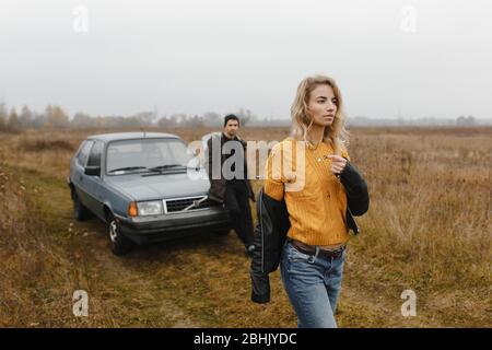 Homme debout près de la voiture et regardant comment va sa femme Banque D'Images