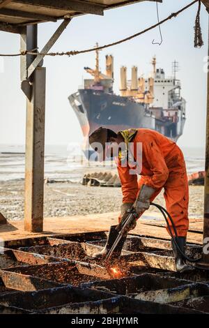 Chittagong, Bangladesh, 23 décembre 2017 : un travailleur coupe la structure de pont métallique d'un navire dans un chantier de démolition de navires à Chittagong, BanGlades Banque D'Images