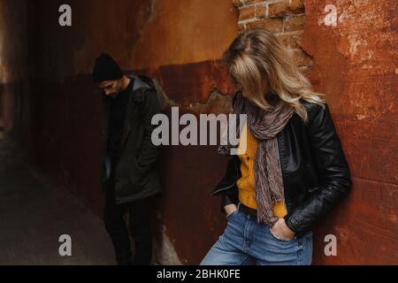 Homme et femme debout à l'arrière-plan du mur avec leurs têtes vers le bas Banque D'Images