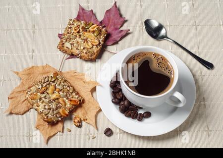 Tasse de café chaud et de biscuits avec noix sur table avec nappe Banque D'Images